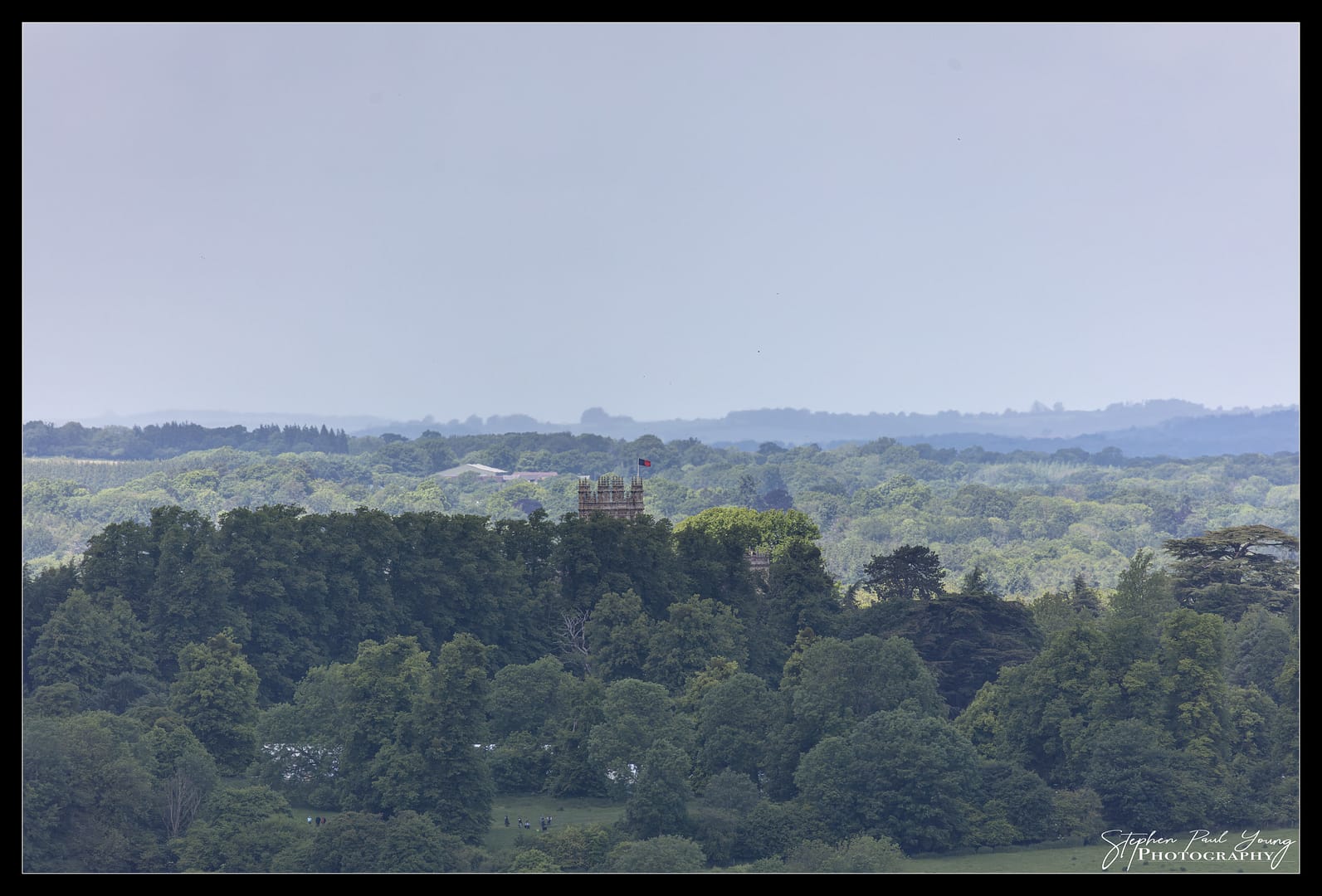 Highclere Castle hidden behind trees. View from Ladle Hill.