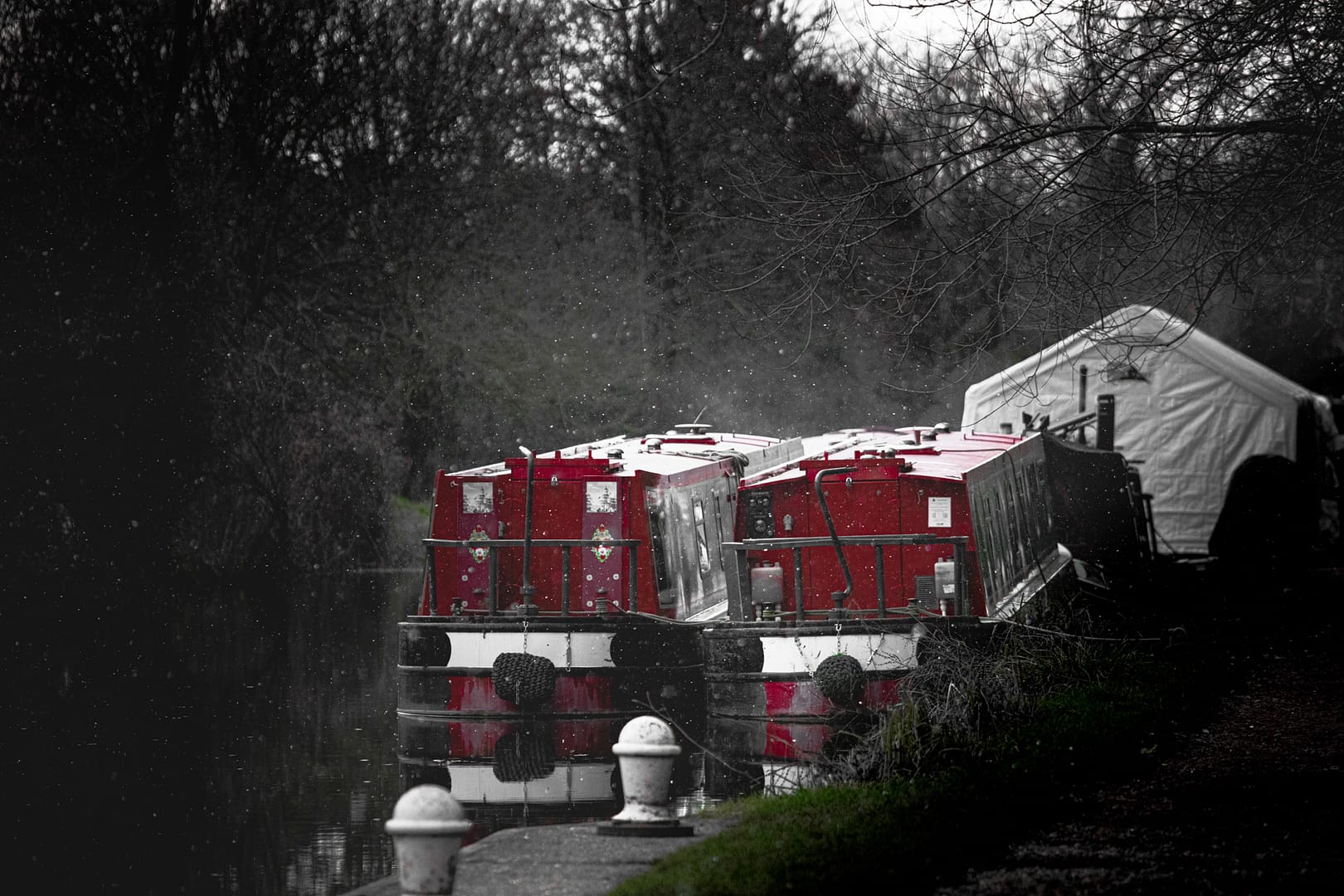 Aldermaston Wharf Winter and 2 Red Narrow boats sit silently as the snow just begins to fall.